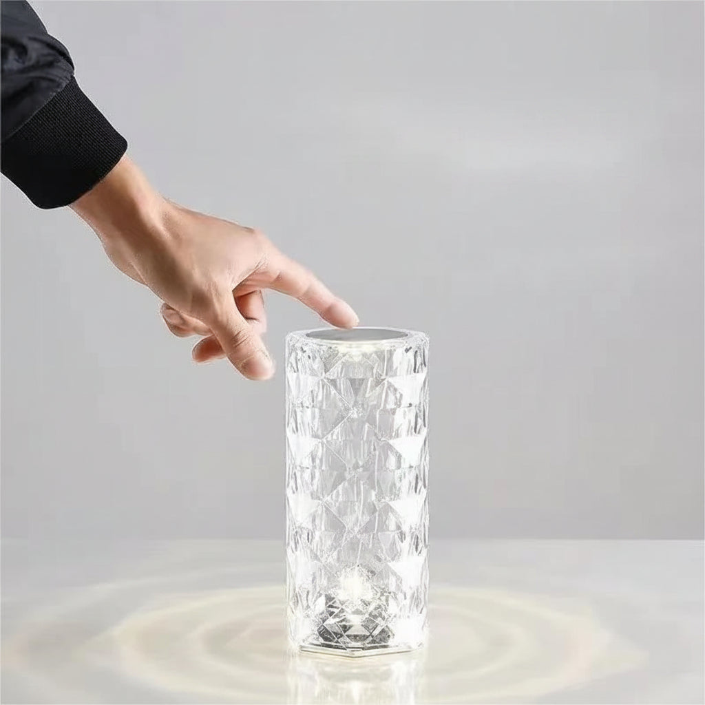 Glass lamp with a hand touching the top surface on a gray background